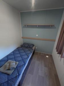 a small bedroom with a bed and a wooden floor at Fishers Paradise am Ebro Mequinenza Zaragoza in Mequinenza