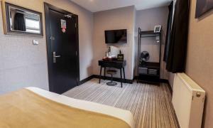 a hotel room with a bed and a desk at Sinclair's Rooms in Southport