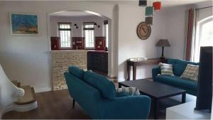 a living room with two blue chairs and a fireplace at Villa au calme et sans vis à vis , proche du village in La Bastide-des-Jourdans