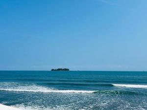 a view of the ocean with an island in the distance at Dept Nuevo 4pers- Alberca- 3 cdr Playa in Boca del Río