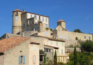 a group of buildings on a hill with two towers at Villa au calme et sans vis à vis , proche du village in La Bastide-des-Jourdans