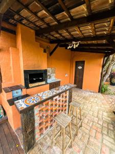 an outdoor kitchen with two stools and a counter at Namaste Flats Praia do Rosa in Imbituba