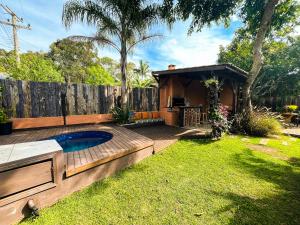 a backyard with a swimming pool and a house at Namaste Flats Praia do Rosa in Imbituba