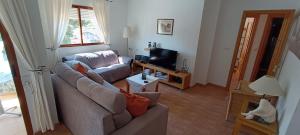 sala de estar con sofá y TV en Apartamento La Marina - VVMU057, en Bolnuevo