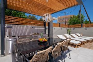 a patio with a black table and chairs on a patio at Tersus Luxury Villa in Kalyves