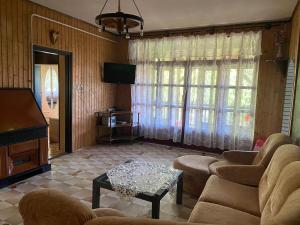 a living room with couches and a tv and a table at Sio-LÁZÁR in Siófok