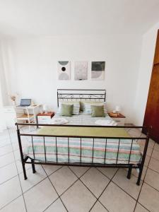 łóżko w pokoju z białą ścianą w obiekcie Casa Picasso Luminoso appartamento 2 camere a Cagliari w Cagliari