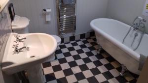 a bathroom with a sink and a tub and a toilet at George Inn, Mere in Mere