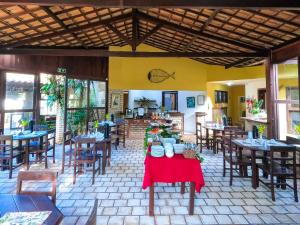 um restaurante com mesas e cadeiras de madeira e mesa em Brasil Tropical Village em Pipa