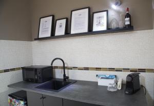 a kitchen counter with a sink and a microwave at Grey Apartment in Caiazzo