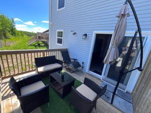 a patio with an umbrella and chairs and a table at Modern Vac Home, private Hot tub, close to airport in Moncton
