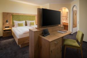 翁肯的住宿－維塔勞斯布魯登酒店，配有一张床和一台平面电视的酒店客房