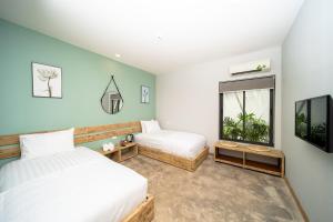 1 dormitorio con 2 camas y ventana en 9Station Hostel & Bar Phu Quoc, en Phu Quoc