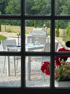 uma vista para uma mesa e cadeiras através de uma janela em Sans Souci Bed and Breakfast Luxe Heated Pool and Restaurant em Luzillé