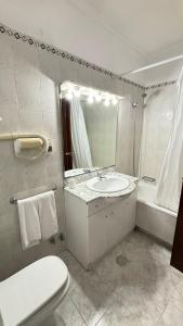 a bathroom with a sink and a toilet and a mirror at Hotel Trindade Coelho in Mogadouro +44 photos