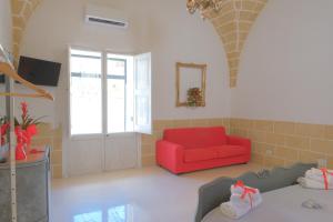 a living room with a red couch and a window at I Ricordi di Anna in Alezio