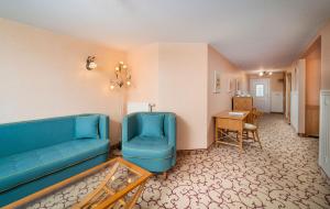 ein Wohnzimmer mit einem blauen Sofa und einem Tisch in der Unterkunft Panorama Seeresort & Spa in Warnitz