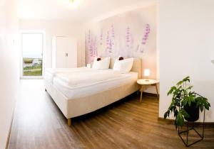 a bedroom with a large bed in a room at Wasserblick Loddin Deluxe 8 in Loddin