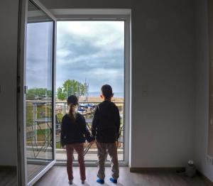 two people standing in front of a large window at Wasserblick Loddin Deluxe 8 in Loddin +4 photos