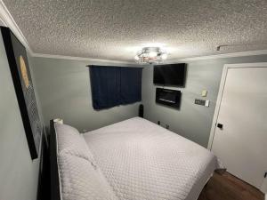 a small bedroom with a white bed and a window at Stroll to Slopes, Village Area, Ski in-out MtLodge 308 in Snowshoe