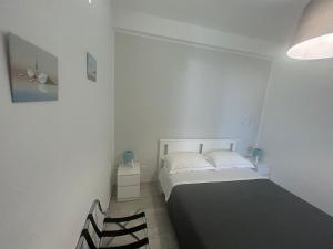 una piccola camera con letto e sedia di SoleeMare Barletta Apartments a Barletta