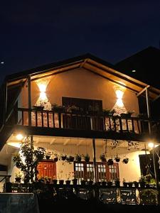 un edificio con balcone di notte illuminato di Cozy Heaven a Nuwara Eliya