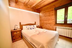 Un dormitorio con una cama en una cabaña de madera. en Las mejores vistas de Andorra en la Vall d'Incles 4-2, HUT-8006, en Canillo