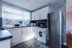 a kitchen with a refrigerator and a washing machine at BIG 7xGuest House 3xVan Locked CarPort Garden Leeds & Bradford in Leeds