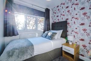 a bedroom with a large bed with floral wallpaper at BIG 7xGuest House 3xVan Locked CarPort Garden Leeds & Bradford in Leeds