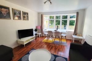 a living room with a table and chairs and a television at BIG 7xGuest House 3xVan Locked CarPort Garden Leeds & Bradford in Leeds