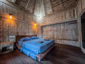 a bedroom with a bed in a wooden room at Coconut Dream in Gili Trawangan