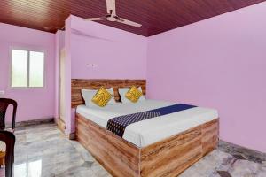 una camera con un letto in una stanza con pareti rosa di OYO Hotel Lambacingi Grands a Lammasingi