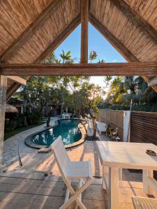 a patio with a table and a swimming pool at Coconut Dream in Gili Trawangan