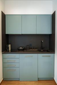 a kitchen with blue cabinets and a sink at Notos Boutique Apartments 3 with Private Jacuzzi in Heraklio +10 photos