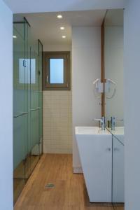 a bathroom with a sink and a glass shower at Notos Boutique Apartments 3 with Private Jacuzzi in Heraklio