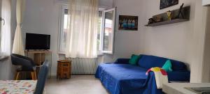 sala de estar con sofá azul y TV en Appartamenti Scilla e Lavinia, en Riva del Garda