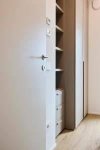 eine Tür, die zu einem Schrank mit weißen Schränken führt in der Unterkunft The Twins 1 Luxury Home - Lungomare Viale Milano 20 in Riccione