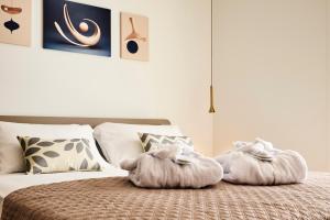 una camera da letto con un letto e asciugamani di The Twins 1 Luxury Home - Lungomare Viale Milano 20 a Riccione