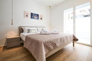 ein Schlafzimmer mit einem Bett mit zwei Handtüchern darauf in der Unterkunft The Twins 1 Luxury Home - Lungomare Viale Milano 20 in Riccione
