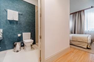 een badkamer met een toilet en een bed bij Apartamentos Soho Boutique Hoy No Me Puedo Levantar in Madrid