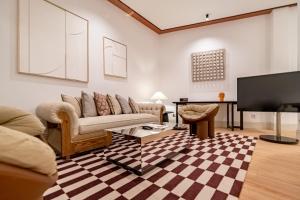 ein Wohnzimmer mit einem Sofa und einem TV in der Unterkunft Apartamentos Soho Boutique Hoy No Me Puedo Levantar in Madrid