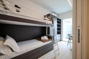 ein Schlafzimmer mit einem Etagenbett mit einer Leiter in der Unterkunft The Twins 1 Luxury Home - Lungomare Viale Milano 20 in Riccione