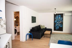Una sala de estar con un sofá negro y una mesa. en V25Appartments, en Bucarest