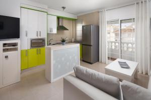 een keuken met gele en witte kasten en een bank bij Ático el morche in Morche