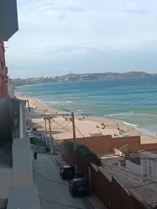 a view of a beach with people in the water at Rue de Paris - Plage Saint Germain - vue sur mer - in 'Aïn el Turk