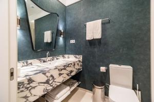 a bathroom with a sink and a toilet and a mirror at Apartamentos Soho Boutique Hoy No Me Puedo Levantar in Madrid