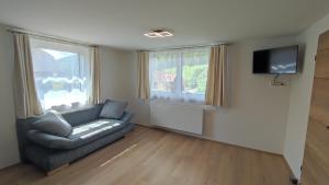 a living room with a couch and a tv at Ferienhaus Steiner in Gries
