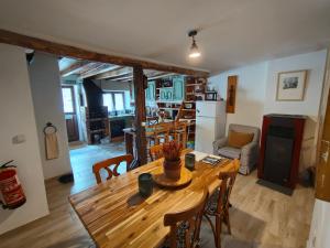 cocina y sala de estar con mesa de madera y sillas en Bellavieja, en Villavieja del Lozoya