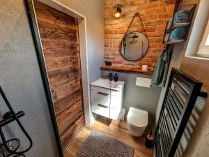 baño con aseo y pared de madera en Liptovalley- mobilné domy s wellnessom, en Liptovská Kokava