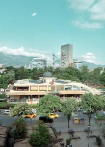 een groot gebouw met auto's geparkeerd op een parkeerplaats bij Goodija Central Tirana 2 in Tirana